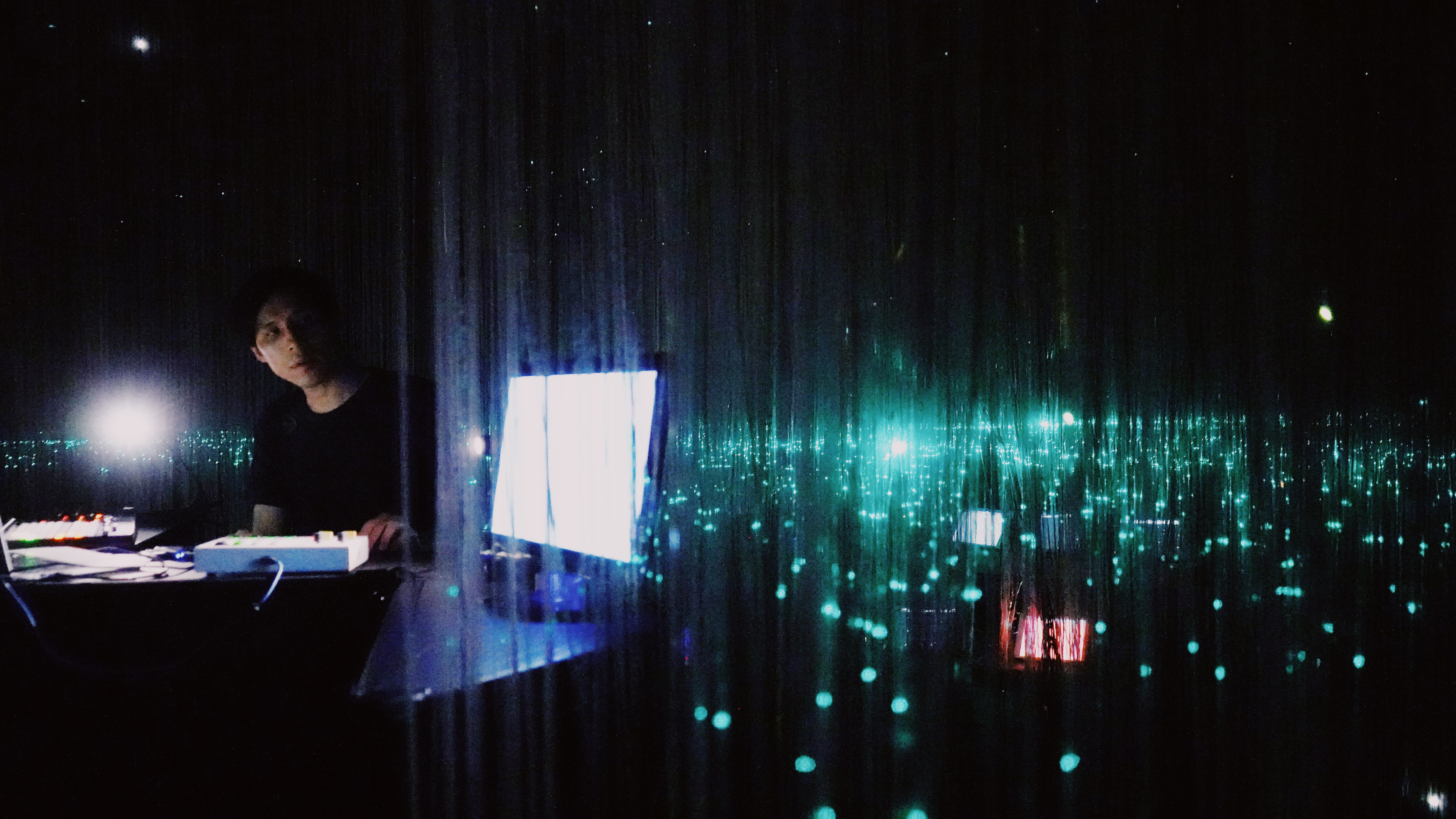 Po-Hao Chi at a control desk behind hanging fiber-optic strands during Duplex Transmission, LAB Creative Lab, Taipei