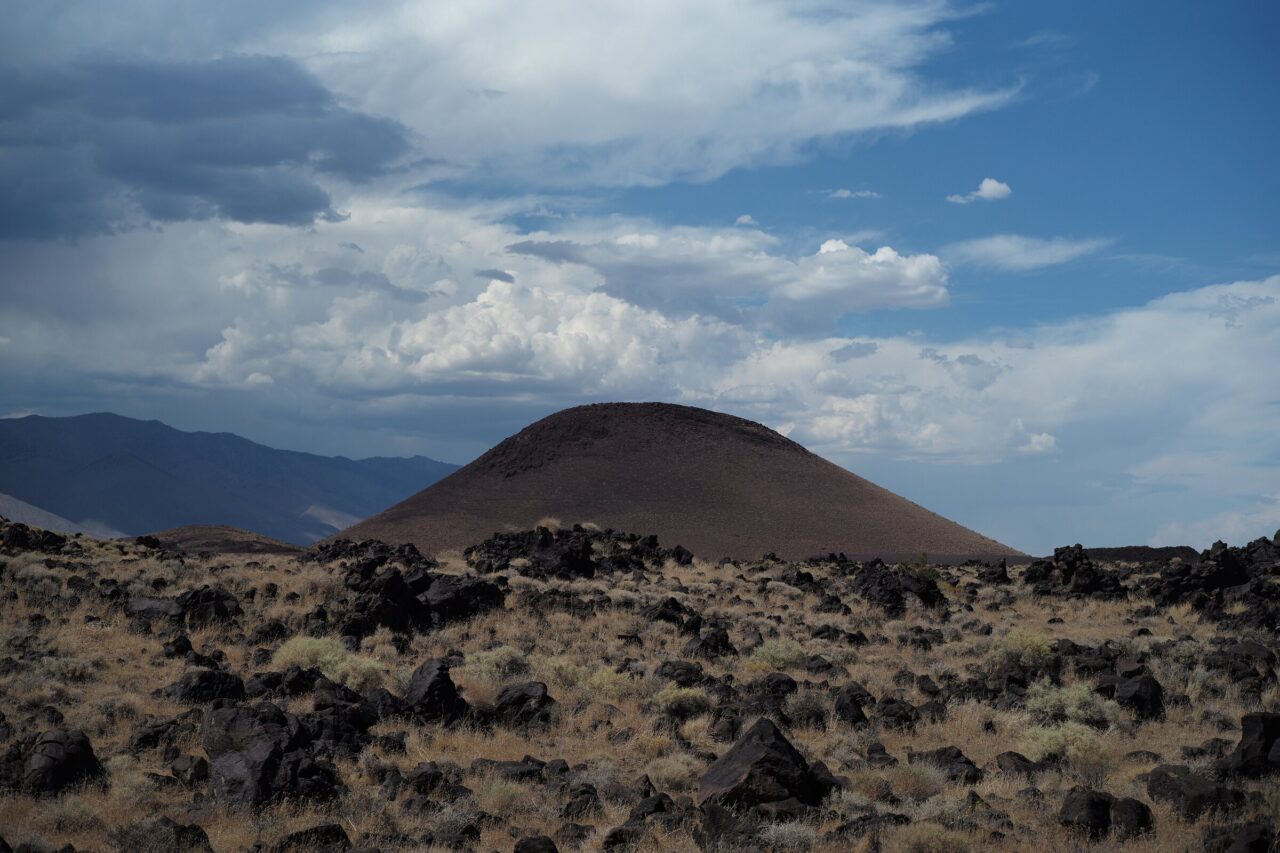 Amboy Crater cinder cone rising above a dark basalt lava field