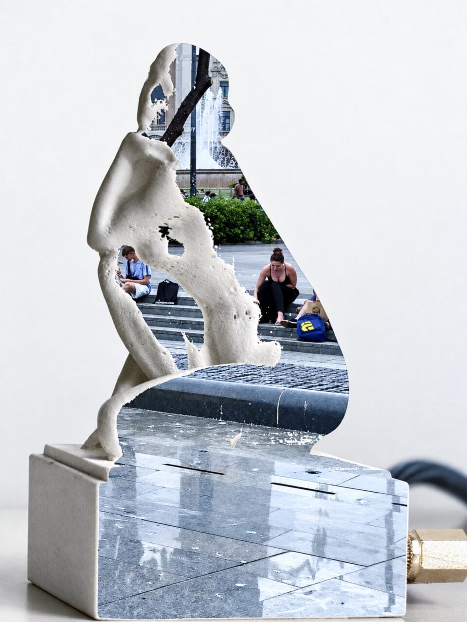 White figure sculpture on a plinth, its silhouette filled with a photo of a plaza with a fountain and people on steps.