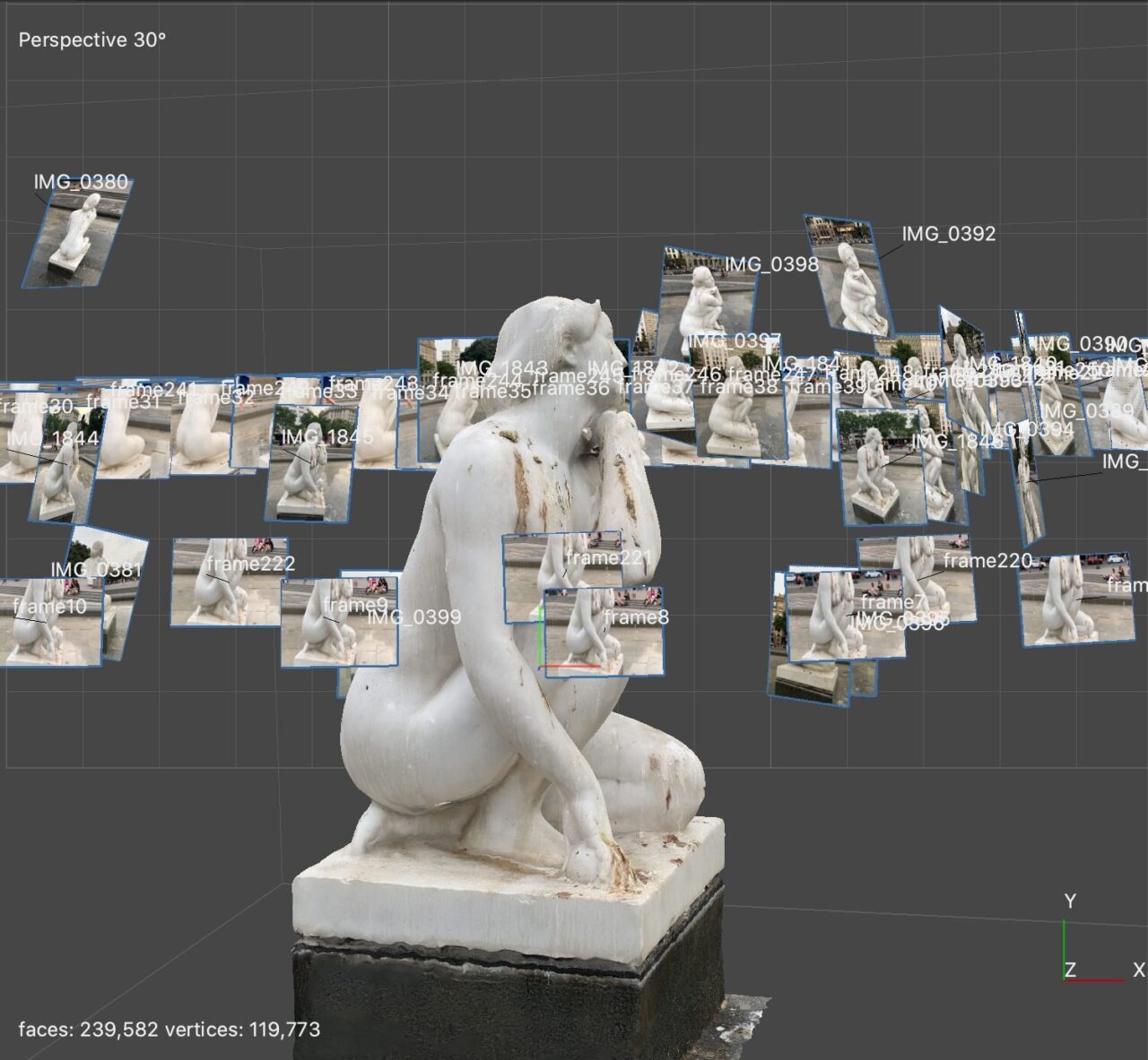 Software view of a white kneeling figure sculpture surrounded by floating photo thumbnails marking camera positions.